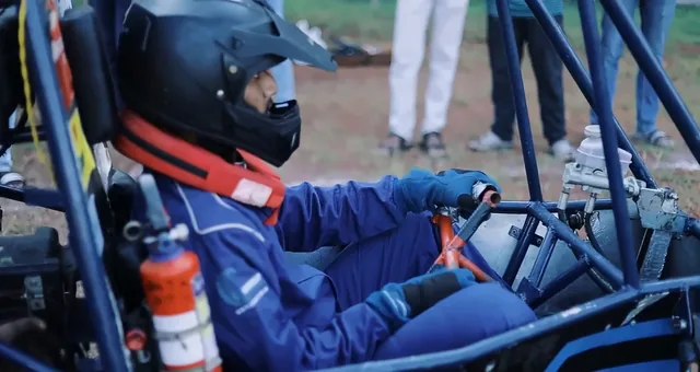 Driver strapped into a Baja ATV cockpit