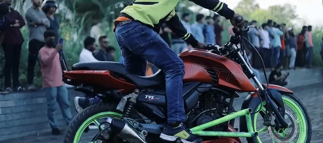 Stunt rider on a motorcycle in front of a crowd
