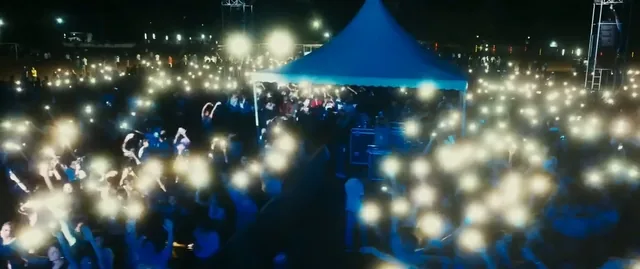 Crowd lighting up the night with phone flashlights
